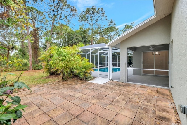 view of patio / terrace with ceiling fan and glass enclosure