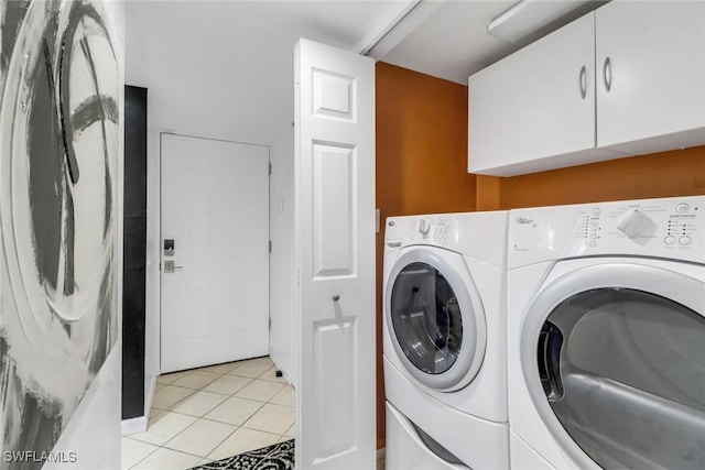 washroom featuring cabinets, light tile patterned floors, and separate washer and dryer