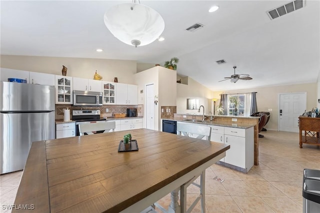 kitchen featuring decorative backsplash, appliances with stainless steel finishes, ceiling fan, sink, and white cabinetry