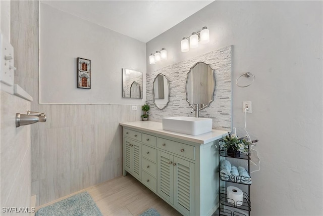 bathroom featuring vanity and tile walls