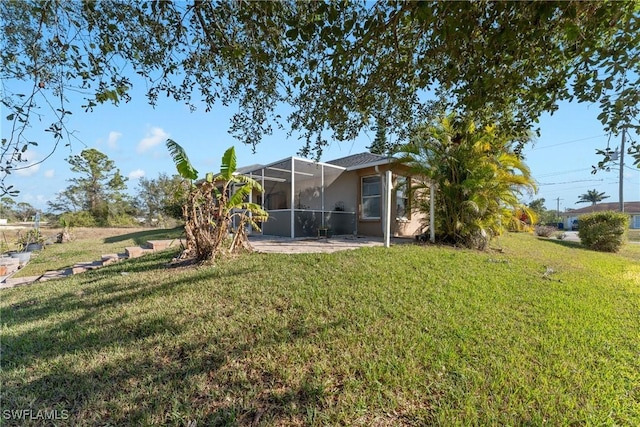 view of yard with glass enclosure and a patio area