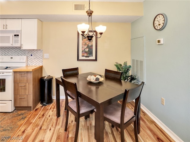 dining room featuring a chandelier and light hardwood / wood-style flooring