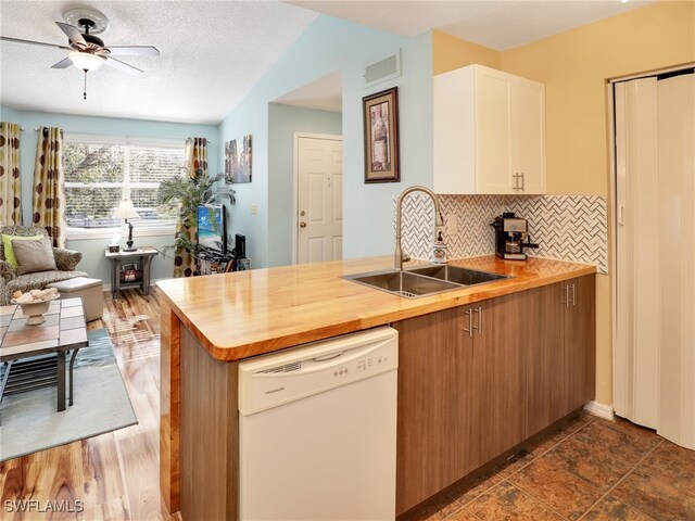 kitchen featuring ceiling fan, backsplash, kitchen peninsula, sink, and white dishwasher