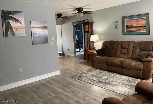 living room with ceiling fan, wood-type flooring, and a textured ceiling