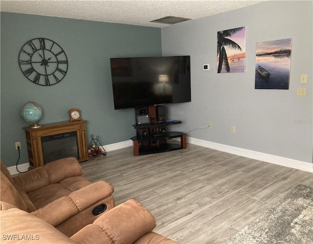 living room featuring wood-type flooring and a textured ceiling