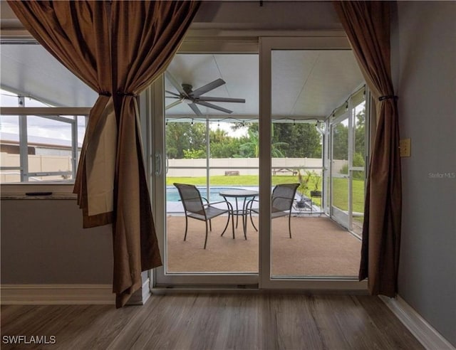 unfurnished sunroom featuring ceiling fan