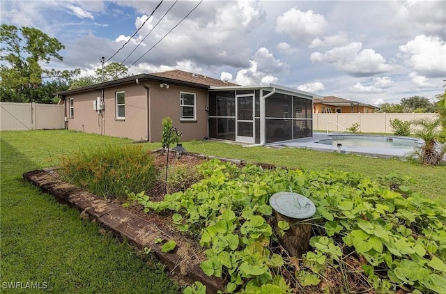 back of property featuring a fenced in pool, a sunroom, and a lawn