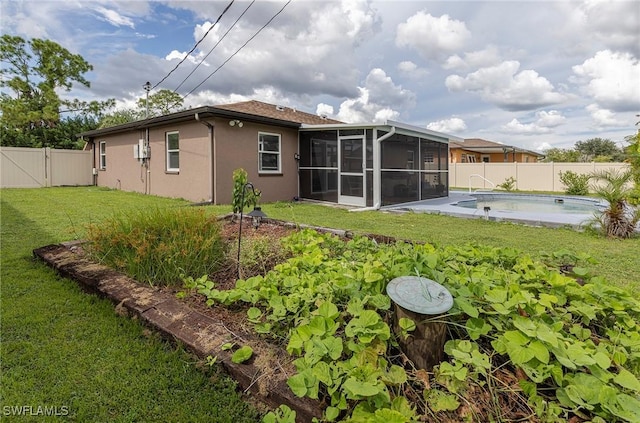 back of house featuring a yard, a fenced in pool, and a sunroom