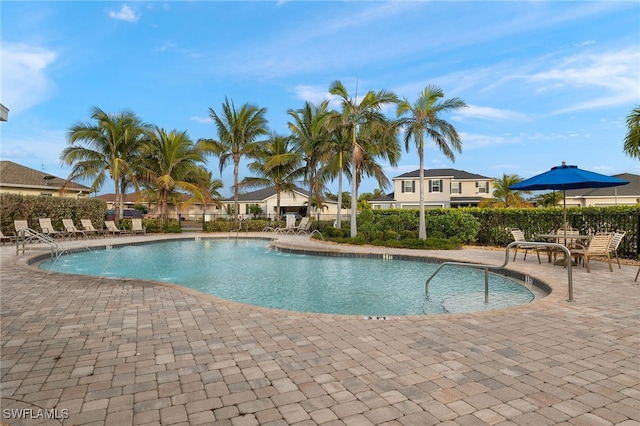 pool with a patio and fence