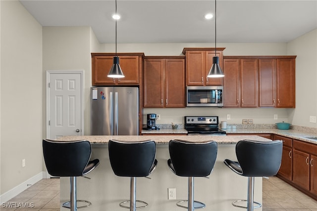 kitchen featuring appliances with stainless steel finishes, a center island, a breakfast bar area, and light tile patterned floors