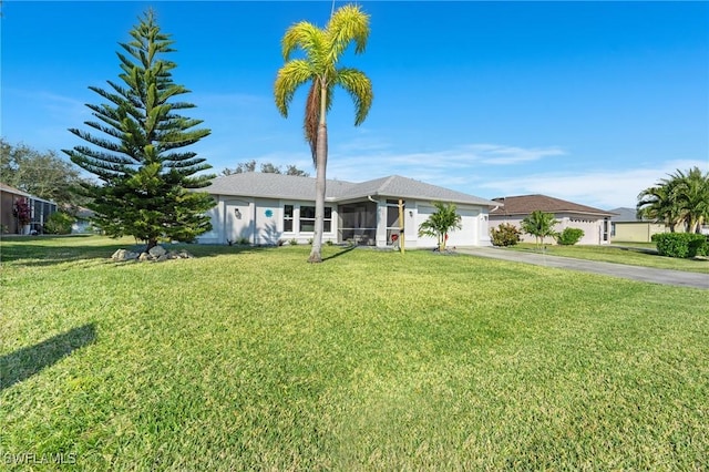 view of front of property with a sunroom, a front yard, and a garage