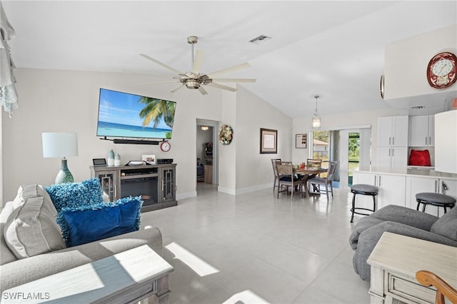 tiled living room featuring ceiling fan and vaulted ceiling