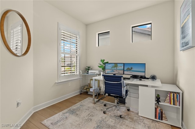 office area with baseboards and light wood-style floors