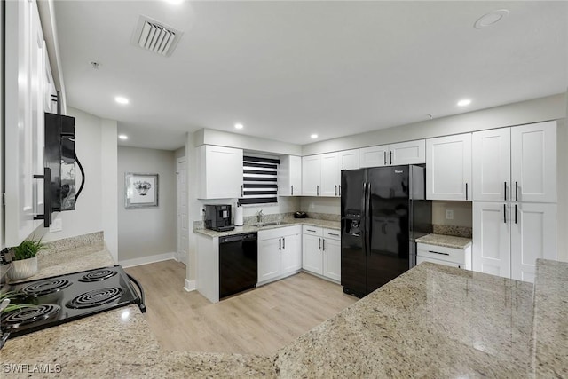 kitchen featuring black appliances, white cabinetry, sink, light stone counters, and light hardwood / wood-style flooring