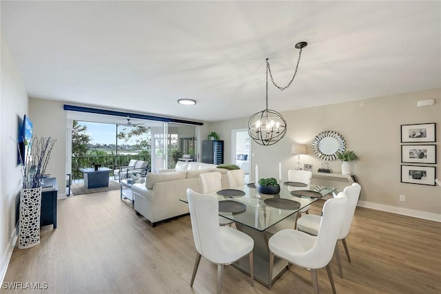 dining space featuring expansive windows, an inviting chandelier, and light hardwood / wood-style floors