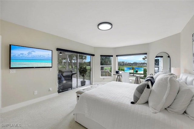 bedroom with access to exterior, a water view, and carpet floors