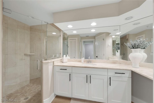 bathroom featuring walk in shower and vanity