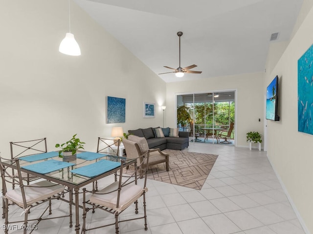 tiled dining space with high vaulted ceiling and ceiling fan