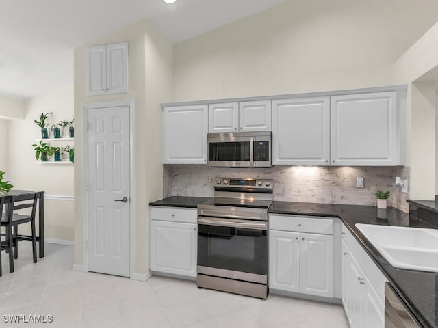 kitchen with white cabinetry, appliances with stainless steel finishes, sink, and tasteful backsplash