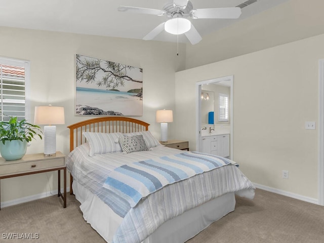 carpeted bedroom with sink, ensuite bath, and ceiling fan