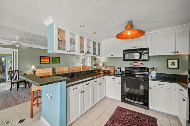 kitchen featuring white cabinetry, light tile patterned floors, and black appliances