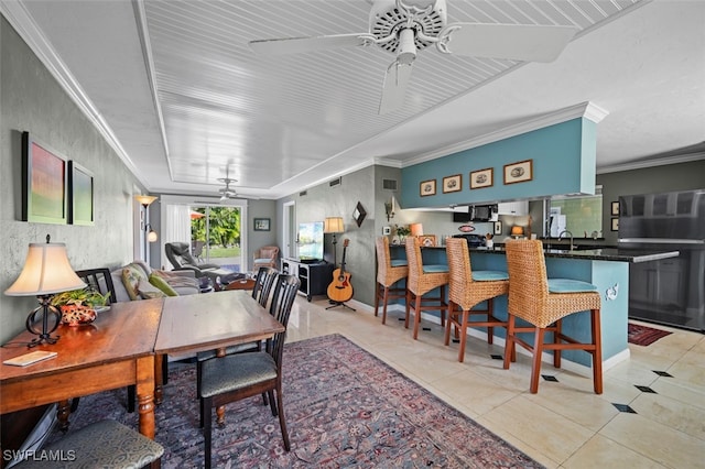 dining space featuring ceiling fan, light tile patterned floors, sink, and crown molding