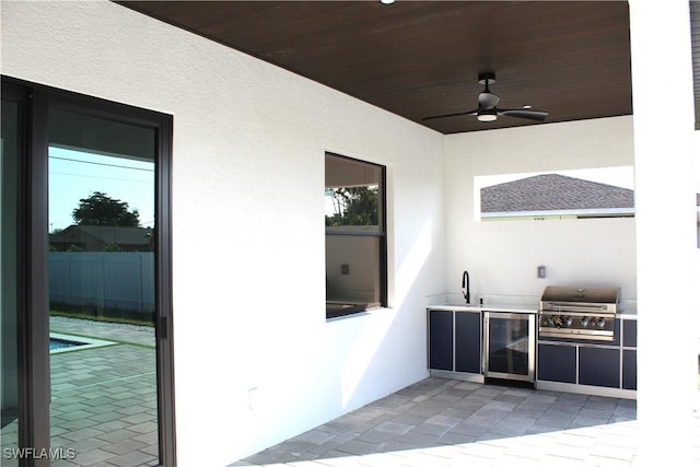 view of patio featuring exterior kitchen, a grill, wine cooler, sink, and ceiling fan