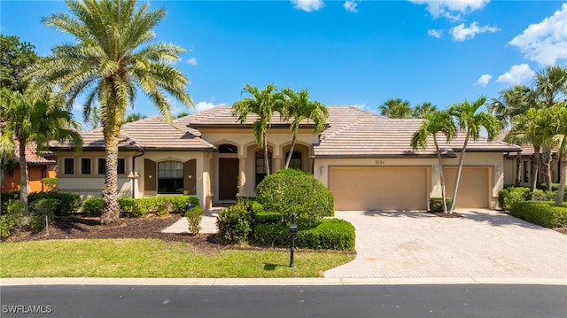 9284 Trieste Dr, Fort Myers, FL 33913 - mediterranean / spanish home featuring a tile roof, a garage, driveway, and stucco siding