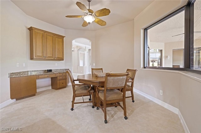9284 Trieste Dr, Fort Myers, FL 33913 - dining area featuring light tile patterned floors, arched walkways, baseboards, and ceiling fan