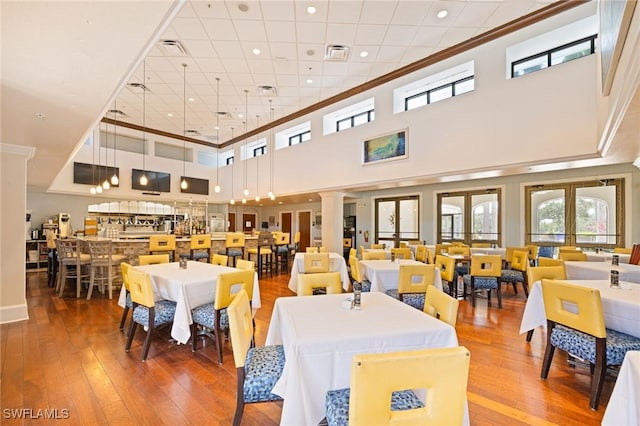 9284 Trieste Dr, Fort Myers, FL 33913 - dining room featuring decorative columns, visible vents, and hardwood / wood-style floors