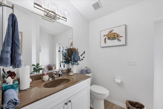 bathroom featuring hardwood / wood-style flooring, toilet, and vanity