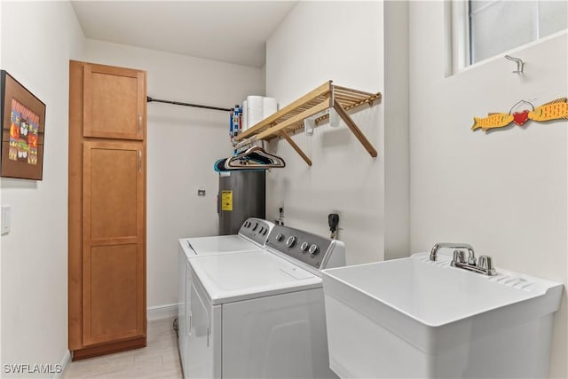 washroom featuring cabinets, electric water heater, sink, and washing machine and dryer