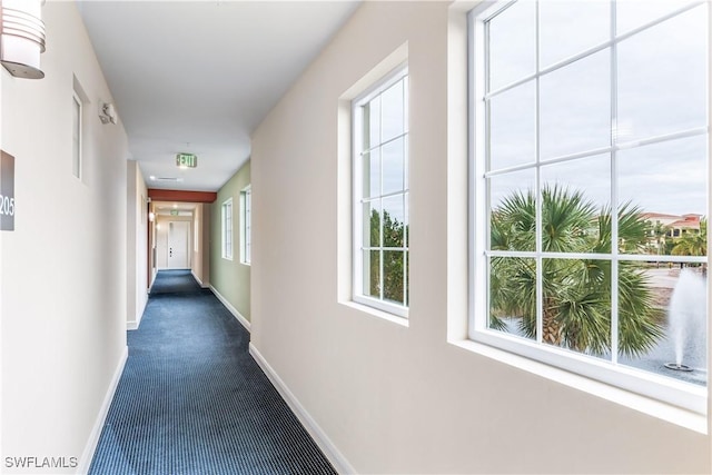 hall featuring dark colored carpet