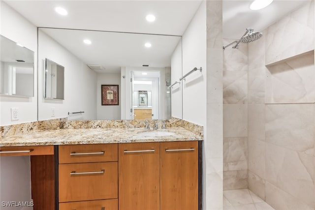 full bath with recessed lighting, tiled shower, and vanity