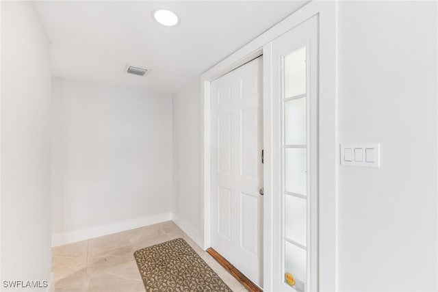 hallway featuring baseboards, visible vents, and recessed lighting