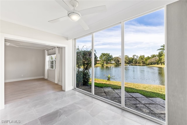 unfurnished sunroom with a water view and a ceiling fan