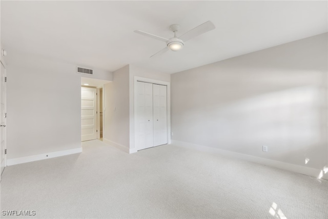 unfurnished bedroom featuring light carpet, a closet, visible vents, and baseboards