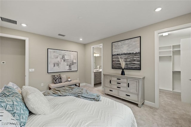 carpeted bedroom featuring a closet, connected bathroom, and a walk in closet