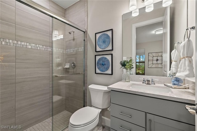 bathroom with toilet, a shower with shower door, and vanity