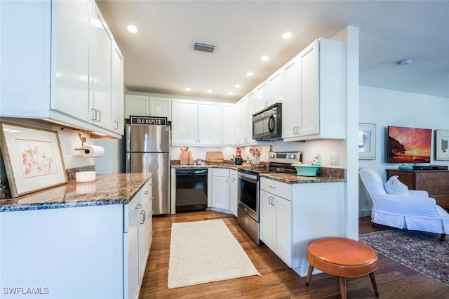 kitchen with wood-type flooring, white cabinets, black appliances, and dark stone countertops