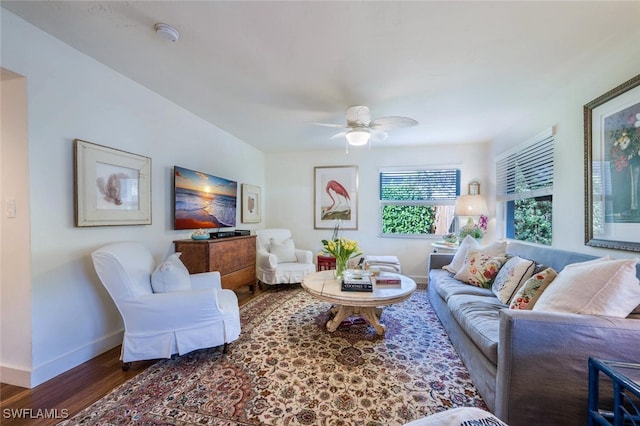 living room featuring ceiling fan and dark hardwood / wood-style floors