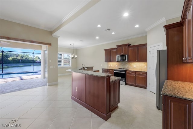 kitchen with decorative light fixtures, crown molding, a kitchen island with sink, stainless steel appliances, and light stone counters