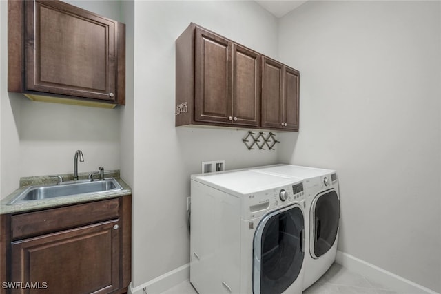 washroom featuring light tile patterned floors, sink, separate washer and dryer, and cabinets