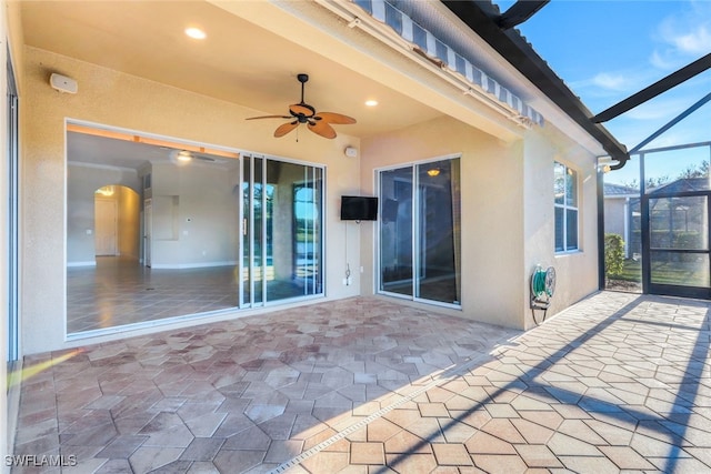 view of patio with ceiling fan and a lanai