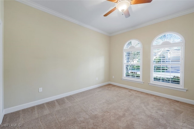 carpeted empty room with ceiling fan, a wealth of natural light, and ornamental molding