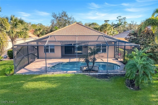 view of pool with a lawn, a patio, and glass enclosure