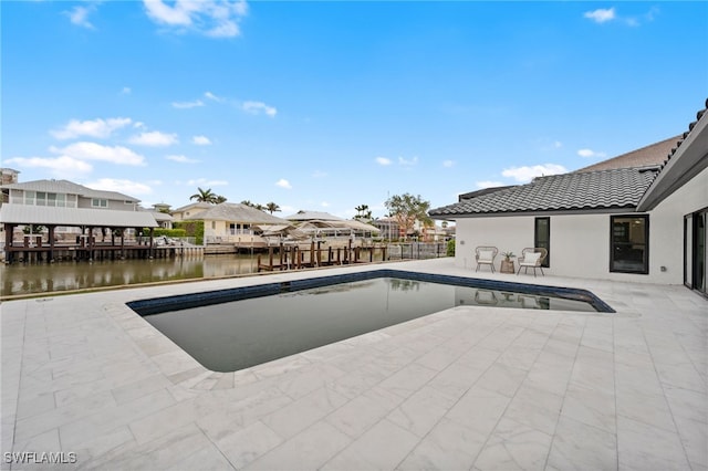 view of pool with a water view and a patio area