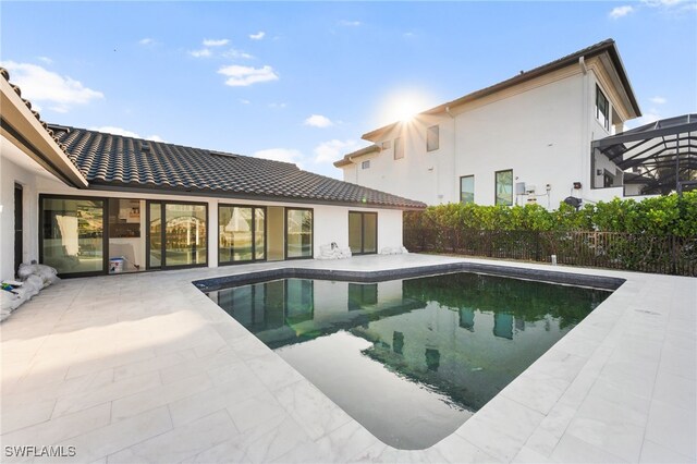 view of swimming pool featuring a patio area and glass enclosure