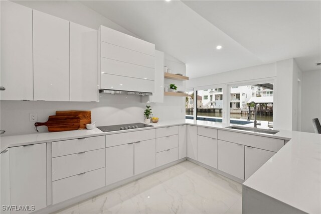 kitchen featuring white cabinetry, lofted ceiling, black electric stovetop, and sink