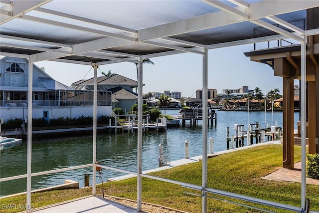 view of dock with a yard and a water view